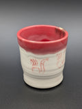 Cup w pipe design and red glaze